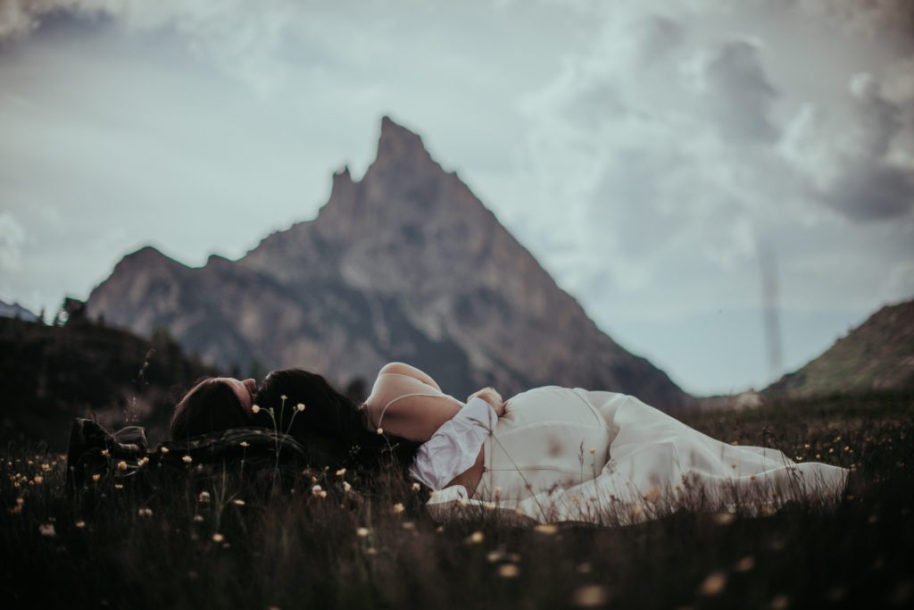 Intimate Wedding In the Dolomites - Luxury Wedding - Couple Laying in the meadows of Alta Badia