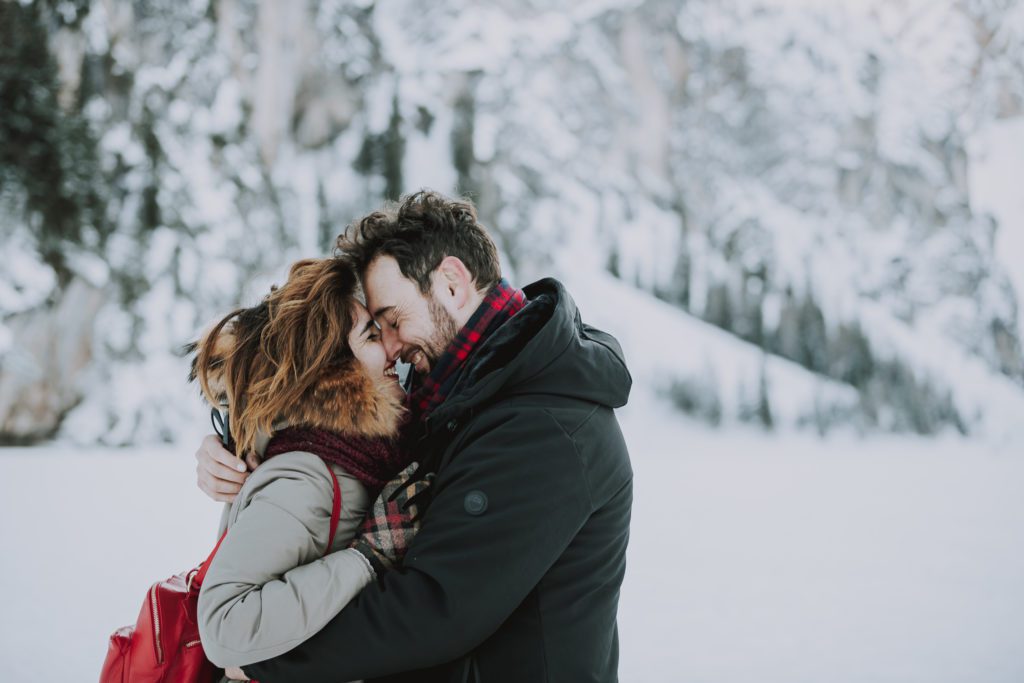 coppia che si bacia in inverno in montagna